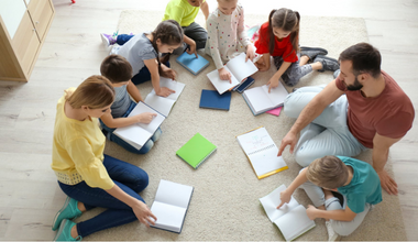 Adults working with a group of children on the floor